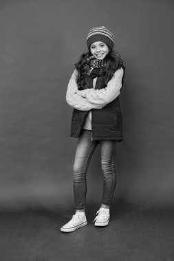 Görünüşünü gündelik kıyafetlerle şekillendir. Küçük çocuklar rahat giyinir. Kırmızı arka planda sıradan giyinmiş küçük bir kız. Sonbahar ya da kış için günlük giysiler. Günlük görüntüye cesur bir not ekle