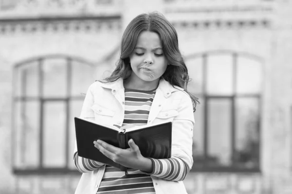 Huiswerk maken is niet leuk. Klein kind doet huiswerk buiten. Klein meisje schrijft in huiswerk dagboek. Huiswerk opdracht. Thuisonderwijs. Privéles. School en onderwijs. Leeromgeving — Stockfoto