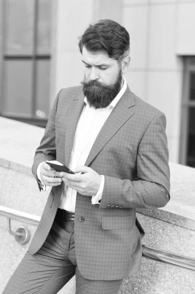 Text messaging. Mobile communication. Email message. Contact list. Online business. Bearded man with smartphone. Handsome cool businessman using smartphone. Send message. Audio message service