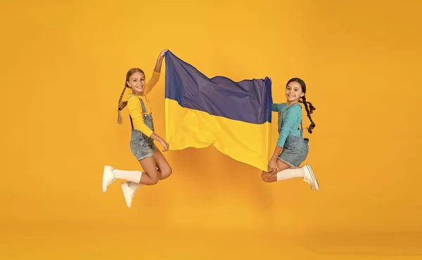 Patriotism respect and love to motherland. National identity concept. Girls with blue and yellow flag. Patriotic education. Happy independence day. Children hold ukrainian flag. Ukrainian kids