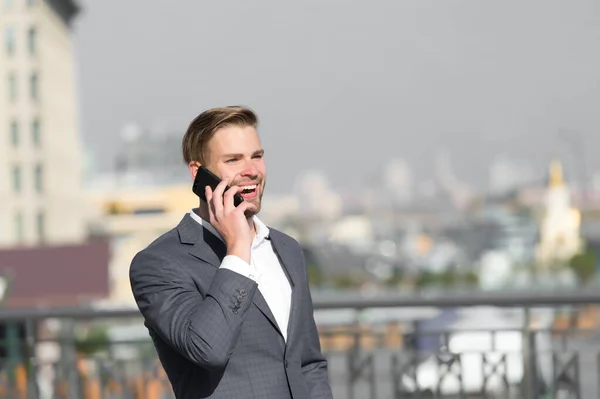 사업가들은 행복하게 웃으면서 스마트폰으로 대화하고 스카이라인을 사용 합니다. 양복입은 사업가는 현대의 이동 통신 기술을 이용 한다. 사업 전화 개념. 야외에서 휴대 전화 통화를 하는 남자 — 스톡 사진