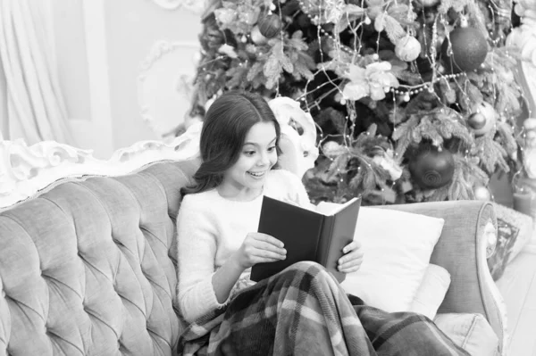 Winter vacation. Magical atmosphere. Fantasy genre. Bookstore concept. Childhood literature. Winter wonderland. Adorable girl reading book christmas eve. Cozy concept. Child enjoy winter holidays