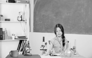 Büyüleyici bir ders. Mikrobiyolojiyi araştır. Biyoloji okuyorum. Biyoloji eğitimi. Fen dersi. Okul laboratuarı. Mikroskobu olan küçük bir kız. Kız biyoloji sınıfı test tüpleri. Bilimsel deney