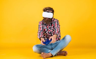 Yeni teknolojileri test ediyoruz. Sanal gerçeklik gözlüğü takan acımasız bir adam. Oyun konsolu. Adam kablosuz internet gözlüğü takıyor. VR kulaklıklı adam. hipster modern teknolojiyi kullanır. Dijital gelecek ve yenilik