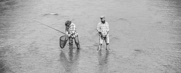 Competition. two happy fisherman with fishing rod and net. father and son fishing. adventures. recreation and leisure outdoor. Big game fishing. male friendship. hobby and sport activity. Trout bait — Stock Photo, Image