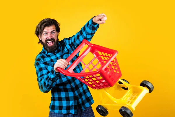Красивый счастливый мужчина ходит по магазинам в супермаркете с тележкой, шопоголиком — стоковое фото