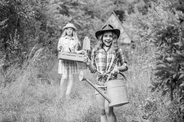 Giardinieri al lavoro. bambino tenere attrezzi da giardinaggio. piccolo agricoltore ragazza con pala e annaffiatoio. felice agricoltura. campagna primaverile. concentrazione selettiva. protezione dell'ecologia. Giorno di terra. fattoria estiva — Foto Stock