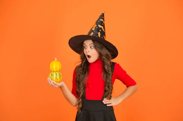 Jack o lantern. happy halloween. surprised kid wear witch hat. child with small pumpkin. teen girl has long curly hair and wear dress for party celebration. autumn season holiday. childhood leisure — Stock Photo, Image