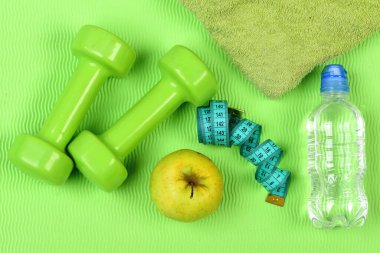 Dambıl, elma ve su şişesi, mavi mezura yakınlarında.