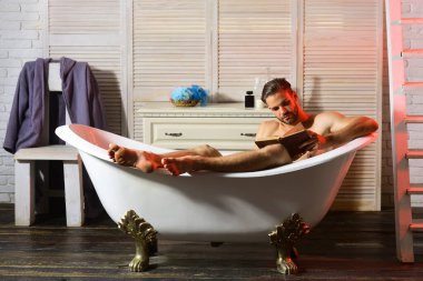 Sakallı ve odaklanmış yüz okuma kitabı olan bir adam.