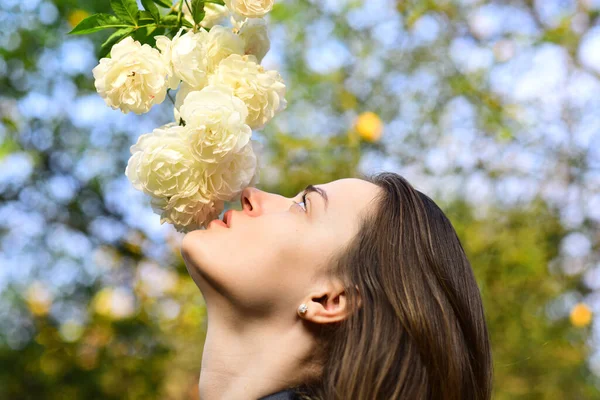 Nő romantikus arc szimatol fehér vagy elefántcsont rózsa — Stock Fotó