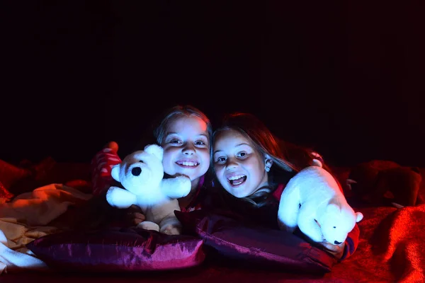 Los niños con caras sonrientes se acuestan en bed.vLos niños en pijama mienten —  Fotos de Stock