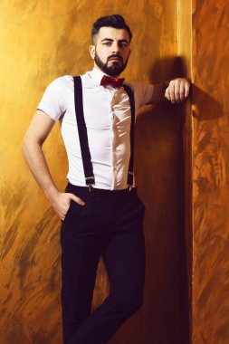 Stüdyo duvarında ciddi bir yüzü olan sakallı bir adam.