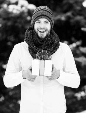 Kışın açık havada hediye kutusu olan yakışıklı bir adam.