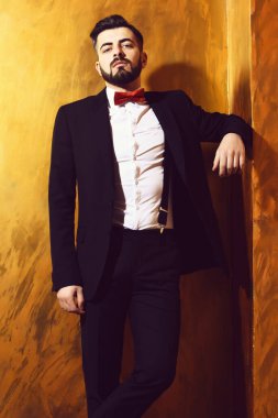 Stüdyo duvarında ciddi bir yüzü olan sakallı bir adam.