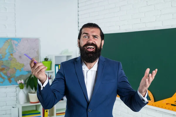 speaker. happy mature teacher smiling. cheerful brutal bearded man work in classroom with blackboard. prepare for exam. college lecturer on lesson. back to school. informal education