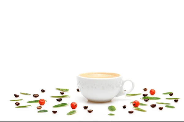 Kopp kaffe med mjölk, kaffeblad, bär och bönor — Stockfoto