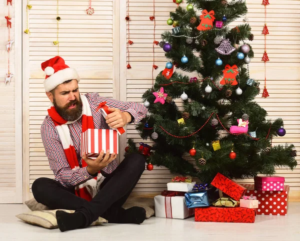 Kerstman met teleurgesteld gezicht op rode slingers achtergrond — Stockfoto