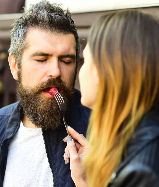 소녀는 포크에 라즈베리를 바른 수염 남자를 먹는다 — 스톡 사진