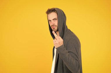 Kaba ve kötü. Kaba adam orta parmak sarı arka plan gösteriyor. Kaba el hareketi. İşaret dili. Kabaca iletişim. Saldırganlık gösteriyor. Asosyal küstah davranış. Saldırgan tavır, kopyalama alanı