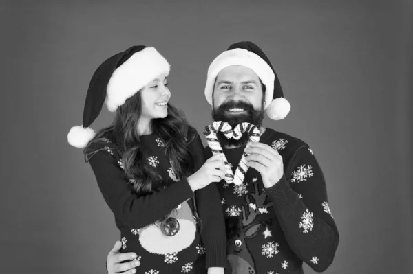 喜びと幸せを分かち合いましょう。クリスマスキャロル。お父さんと娘のお菓子の犬のクリスマスの装飾。家族の休日。サンタ・クラスの家族みたいに。髭を生やしたお父さんと陽気な女の子。クリスマスゲーム — ストック写真