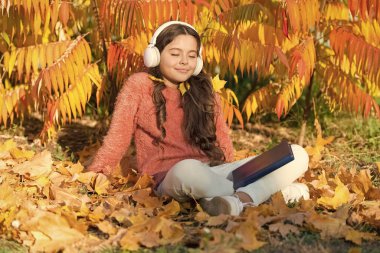 Elderning 'in başladığı yerde. Küçük bir çocuk sonbahar günü para kazanıyor. Küçük kız internette sarı yapraklarla öğreniyor. Uzaktan eğitim ya da kazanç. Online rota. Eğitim teknolojisi. eLearning