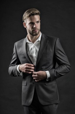 Şık ve başarılı. Çoğu işletme, kıyafet zorunluluğunun profesyonel kıyafet olduğunu açıkça belirtir. Adam iyi giyimli koyu renk bir arka plan. İş elbisesi kuralı. Erkek kıyafeti.