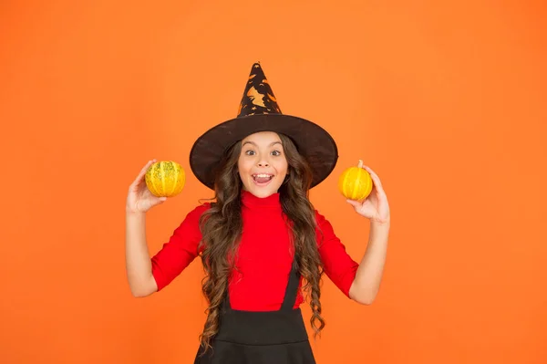 Divertido niño en traje de bruja sombrero para Halloween con calabaza o calabaza sobre fondo naranja, jack o linterna —  Fotos de Stock