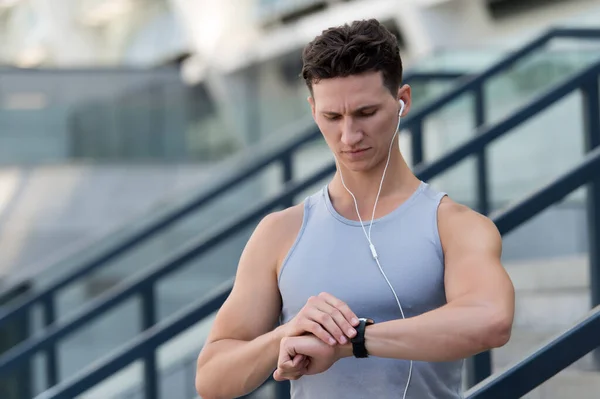 Handsome sportsman set up fitness application with smart watch