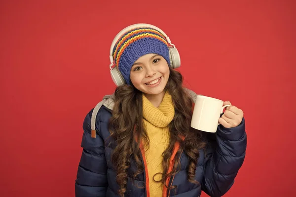 Weekend begins like that. Hipster fashion trend. Winter holidays activity. Feeling warm and happy. Cheerful smiling child stylish outfit listen music. Listening music and drinking cocoa. Music taste
