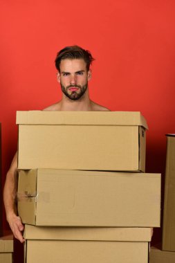 Güçlü kolları olan bir adam karton kutuları tutuyor.