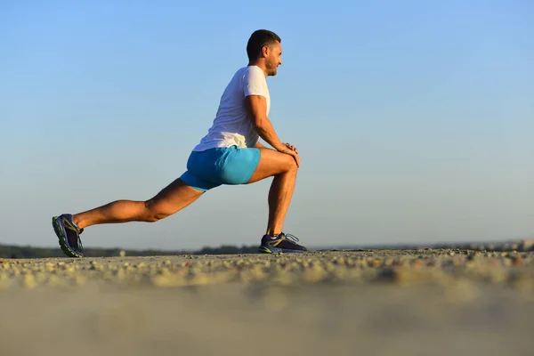 Een man met een sportief figuur strekt zich uit. Trainer doet opwarmoefeningen — Stockfoto