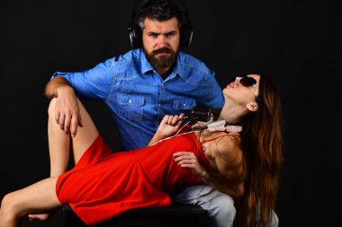 Sakallı ve ciddi yüzlü bir adam hoparlörde kızı tutuyor.