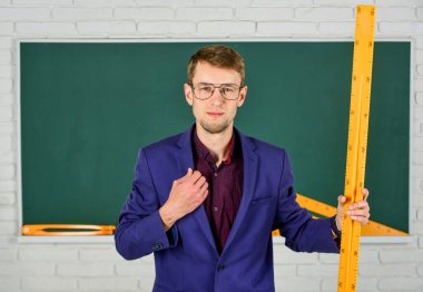 Tahtadaki adam. Okula dönüyorum. Boyutu ne? Geometri favori konusu. Erkek öğretmen matematik cetvelini tutuyor. Eğitim ve okul konsepti. Kök okul disiplini. Matematik ve insanlar kavramı