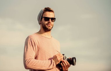 Hayat anları ekliyorum. Kameralı maço adam. Kamerayla seyahat et. Erkek modası. Moda görünüyor. Macera yakalamak. Gazeteci. Seksi turist muhabiri. gözlüklü fotoğrafçı