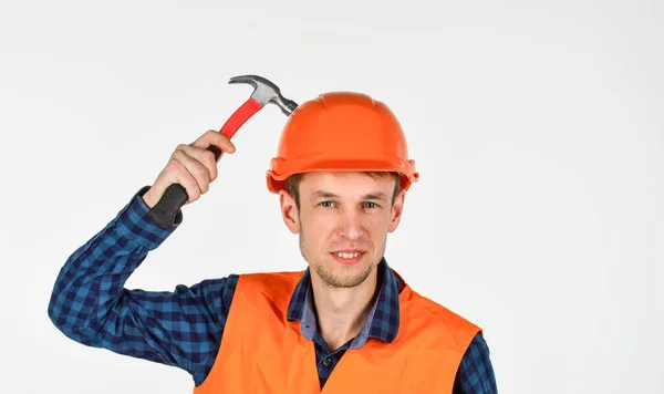 A férfi építő kalapácsot használ. Profi szerelő sisakban. építés és építés. képzett építész javítás és javítás. mérnöki munkás karrier. javítandó szerszámok. fiatal férfi kemény kalapban — Stock Fotó