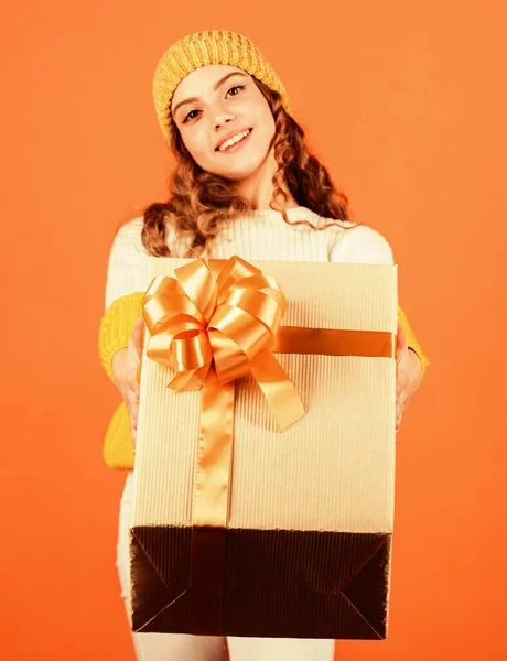 Születésnapi hagyomány. Divatos kislány kötött sapkát és pulóvert visel. Születésnapi meglepetés. Csinos tini smink arc göndör frizura. Ajándékdoboz a kölyöknél. Bevásárlóközpont. Születésnapi ünnepség ötlet — Stock Fotó