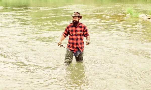 Homem pescador barbudo. A pesca requer estar atenta e plenamente presente no momento. Equipamento de pesca Fisher. Descanso e recreação. Passatempo masculino Fisher. Peixe no anzol. Brutal homem ficar na água do rio — Fotografia de Stock