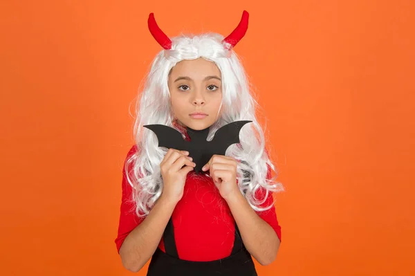 Boldog gyermek Halloween viselni vicces karnevál jelmez és szarvak beltéri gazdaság kis denevér, kísérteties halloween — Stock Fotó
