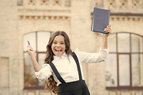 Superare il test con successo. Una studentessa. Il concetto di istruzione scolastica. Giorno della conoscenza. Imparare la lingua. I migliori libri di testo per imparare a casa. Apprendista. Carino sorridente bambino tenere libro — Foto Stock