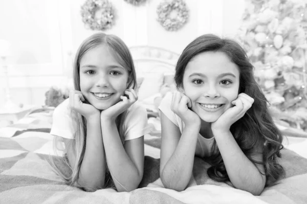 Η ευτυχία ζει εδώ. Ευτυχισμένα παιδιά χαμογελούν στο κρεβάτι. Τα μικρά κορίτσια απολαμβάνουν την ευτυχία παραμονή Χριστουγέννων. Παιδική ευτυχία. Συναισθηματική υγεία. Ευτυχισμένη παιδική ηλικία. Διάλεξε την ευτυχία. Περίοδος διακοπών σε οικογενειακό κύκλο — Φωτογραφία Αρχείου