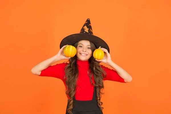 Joyeux anniversaire. adolescent fille a des cheveux longs robe d'usure pour la fête. vacances d'automne. loisirs d'enfance. Jack o lanterne. Joyeux Halloween. Il porte un chapeau de sorcière. enfant avec petite citrouille — Photo