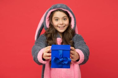 Mutlu çocuk tavşan kigurumi pijaması giyer mavi hediye kutusunu paylaşır, alışveriş yapar.