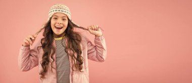 Sevimli küçük çocuk örülü aksesuar giyiyor. Moda aksesuarları ve pembe geçmişi olan sevimli küçük bir kız. Kıyafet dükkanı. Kış mevsimi için çocuk şapkaları. Aksesuar kafa koruması. Moda tarzı aksesuarlar