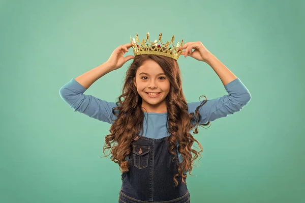 Criança egoísta cabelo encaracolado longo. luxo e sucesso. encontrar a sua motivação. Menina pequena na coroa rainha. Sente-se como uma grande chefe. ser um egoísta. recompensa pelo verdadeiro campeão. pequena princesa — Fotografia de Stock