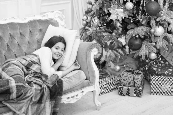 Magiczna chwila. Podekscytowany przed Bożym Narodzeniem. Szczęśliwego Nowego Roku. Rodzinne wakacje. Choinka i prezenty. Dzień przed świętami. Mała dziewczynka leżała na kanapie w pobliżu choinki piękne wnętrze — Zdjęcie stockowe