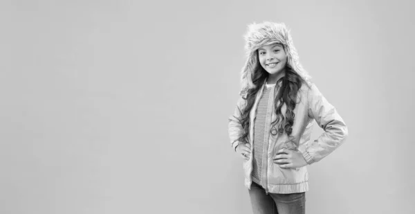 Concept de mode d'hiver. Chapeau chaud par temps froid. Fausse fourrure tendance. Enfant ludique fille porter un chapeau de fourrure avec des rabats d'oreille fond rose. Accessoire en fourrure souple. Enfant cheveux longs chapeau de fourrure douce profiter de la douceur — Photo