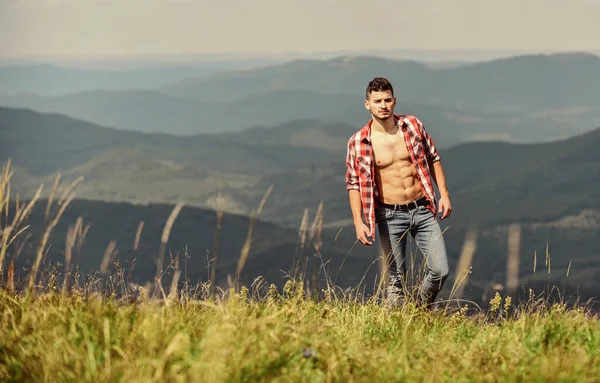 Musculoso paseo turístico colina de montaña. El torso muscular del excursionista alcanza el pico de montaña. Atleta chico relajar montañas. Hermoso ambiente. Concepto de senderismo. Hombre stand superior montaña paisaje fondo — Foto de Stock