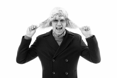 Moda uzmanı. Olgun model soğuk havanın tadını çıkarıyor. Moda adamı için kışlık kıyafet. Moda adamı kürklü şapkalı aksesuar. Kürk onu soğuktan korur. Göz aksesuarı