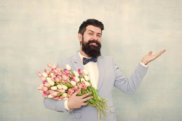 Choisissez et commandez un cadeau. Homme barbu avec un cadeau de fleurs fraîches. Joyeux hipster avec des tulipes. Cadeau floral pour la Saint Valentin. Cadeau de Saint Valentin pour les femmes. Valentine homme tenir la main vide pour l'espace de copie — Photo